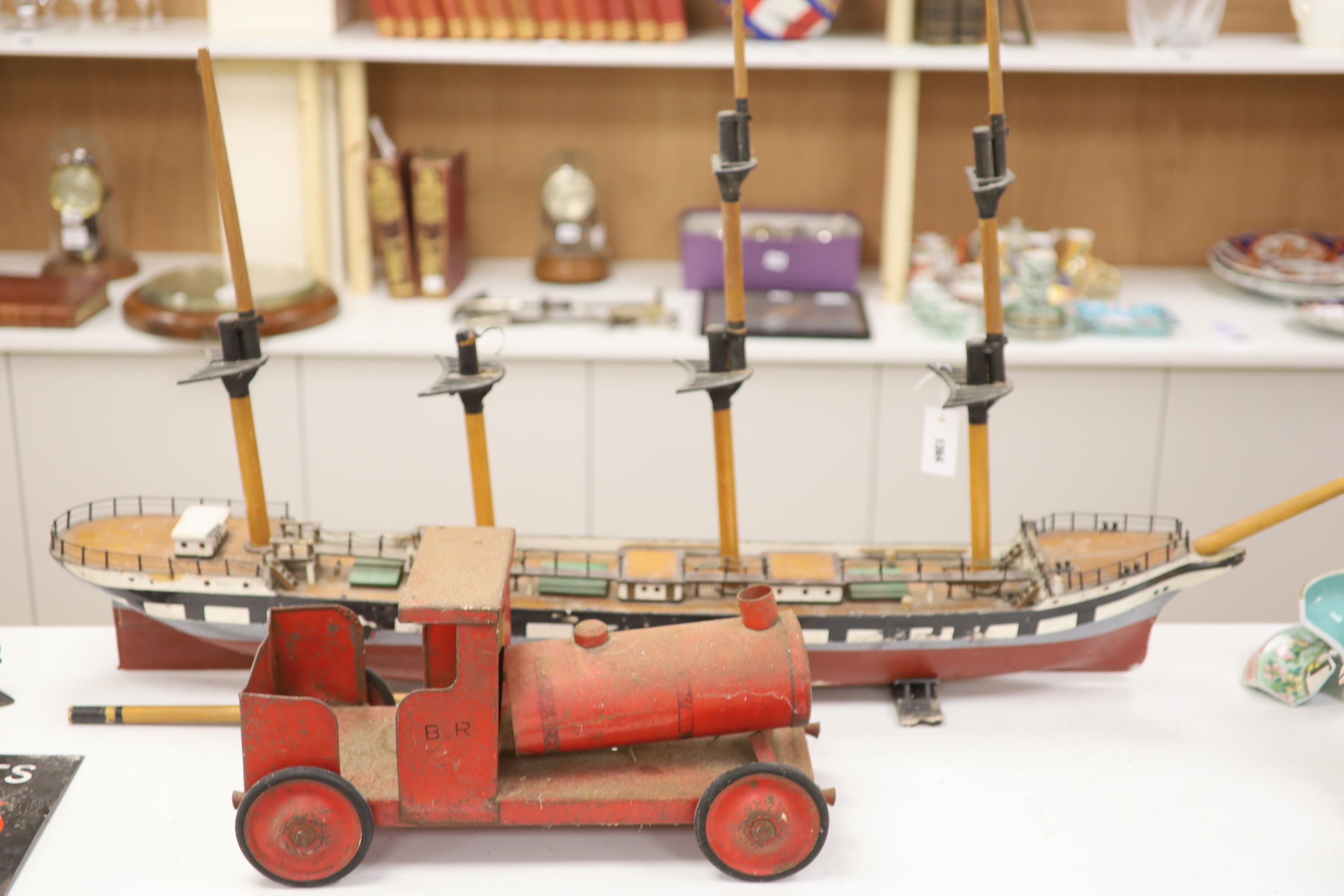 A scratch built primitive model of a cutter and an enamelled metal model of a locomotive, longest 137cm